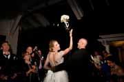 Bride throws bouquet as she leaves her Beach Club wedding reception.
