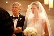 A father gives away his daughter at her wedding ceremony.