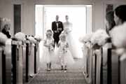 A black and white photo of flower girls dropping flower petals before wedding ceremony.