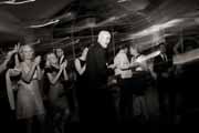 Black and white photo of a groom dancing at his wedding reception.