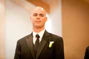 A groom watches his bride approach at their wedding.
