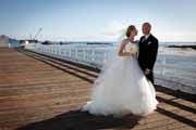 A new bride and groom share a loving look on the Beach Club pier in Pebble Beach.