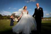 Newlyweds walk along coast in Pebble Beach, California.