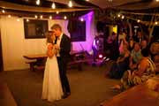 Newlyweds embrace at their Big Sur Bakery wedding reception.