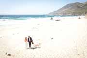 Newlyweds stroll along Garrapata State Beach in Big Sur after their wedding.