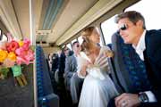 Newlyweds and weddings guests ride on shuttle bus.