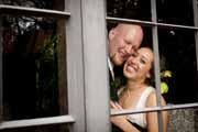 Bride and groom laugh as seen through a window at the Brazilian Room.