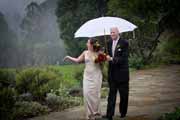 A bride and groom walk through the rain at their Brazilian Room wedding in Berkeley.