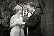 A black and white photo of a backyard wedding ceremony.