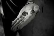 A black and white photo of wedding rings in groom's hand.