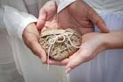 A heart-shape wedding ring cushion made of twine.