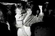 Black and white photo of bride dancing with child.
