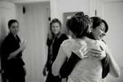 Black and white photo of bride embracing friend.