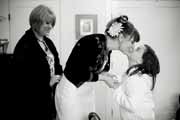 Black and white photo of bride kissing wedding flower girl.
