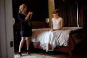 A friend takes a snapshot of bride.