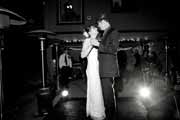Black and white photo of newlyweds dancing during wedding reception.