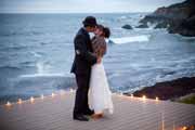 Newlyweds kiss overlooking ocean near Half Moon Bay.