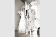 Black and white photo of bride and groom with door between them.