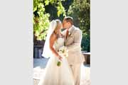 Newlyweds kiss under grape trellis at Holman Ranch in Carmel Valley.