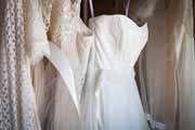 Wedding gown and rack with white bridesmaids dresses.