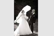 A groom plays with his bride's veil.