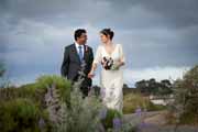 A bride and groom stroll in the dunes in Pebble Beach, California.