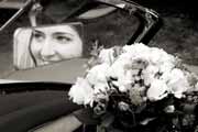 A black and white portrait of a bride reflected in a car mirror.