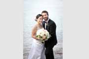 Newlyweds pose by the water after their Perry House wedding in Monterey, California.
