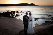 Newlyweds watch the sunset over Point Lobos, California.