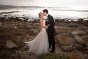 A bride and groom embrace at Asilomar Beach in Pacific Grove, California.