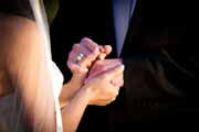 Bride and groom hold hands during wedding.