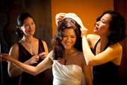Bride's mother puts veil on her daughter.