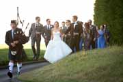 A bagpiper leads a wedding reception parade in Pebble Beach.