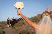 A bride waves to her wedding guests at the Inn at Spanish Bay.