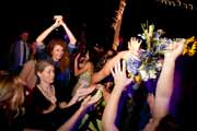 Wedding guests catch a tossed bridal bouquet.
