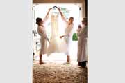 Bride holds wedding gown.