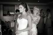 Black and white photo of bride's mother adjusting wedding veil.