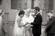 Black and white wedding photo of ring exchange.