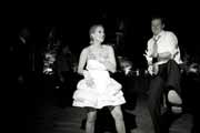 Black and white photo of bride and air guitarist.