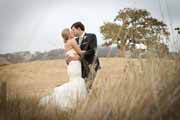 Newlyweds kiss at Santa Lucia Preserve in Carmel Valley by coast live oaks.
