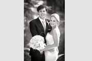 Black and white wedding portrait of smiling newlyweds.