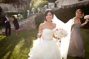 Bridesmaid carries bride's veil.