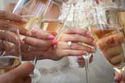 Champagne toast hand detail with engagement ring.