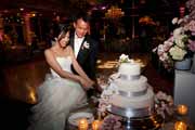 Bride and groom cut wedding cake at Beach Club reception.