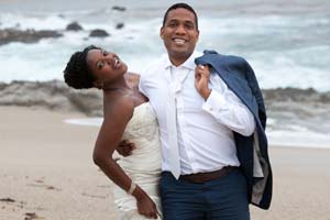 Smiling newlyweds stroll on a beach near Carmel-by-the-Sea