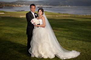A formal wedding portrait of a newly-married couple on the 18th Lawn by the Pebble Beach Golf Links.