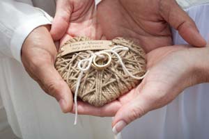 Wedding rings tied to a twine heart.